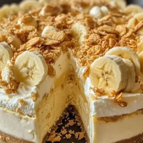 Slice of Banana Pudding Crunch Cheesecake with whipped cream and banana slices