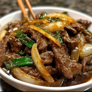 Delicious beef stir-fry with onions in a sizzling pan