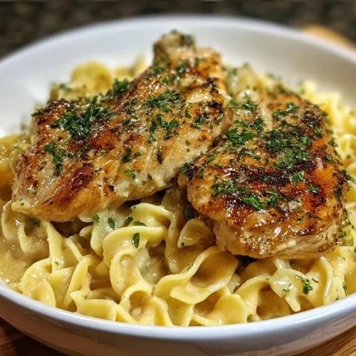 Plate of Chicken with Buttered Noodles garnished with herbs