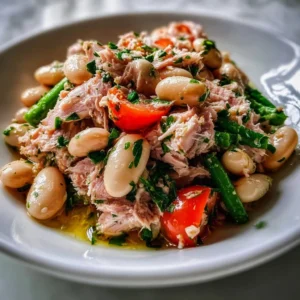 Delicious Tuna and White Bean Salad topped with fresh herbs and vegetables.