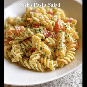 A colorful no mayo pasta salad served in a bowl with fresh vegetables.