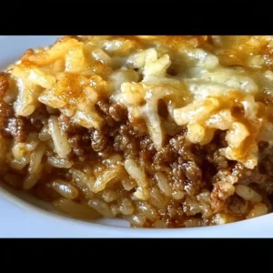Delicious French onion casserole with ground beef and rice, topped with melted cheese.